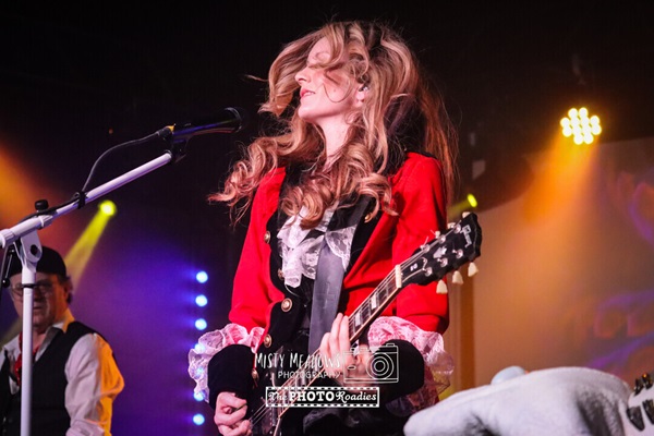 Woman playing guitar on stage